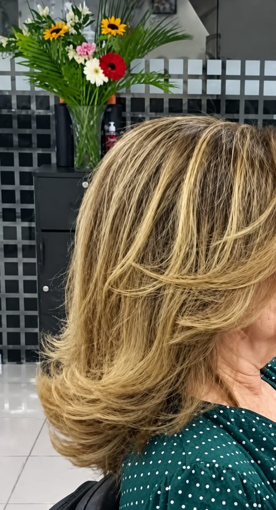 Cabelo loiro com mechas e escova modelada em camadas no Toque Classe