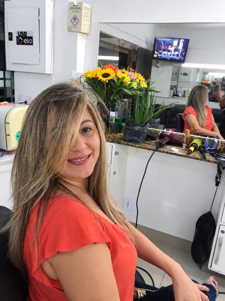 Cliente com mechas iluminadas e escova modelada no salão Toque Classe